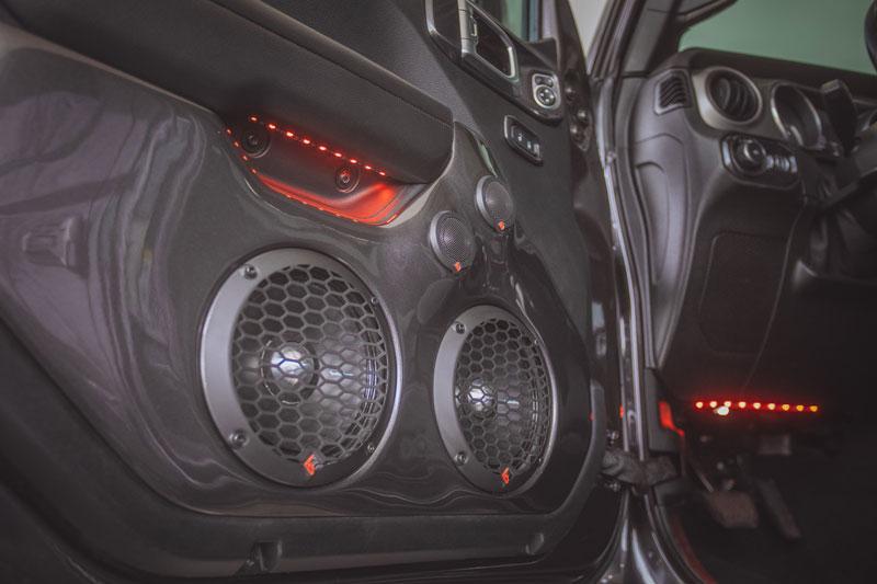 Rockford Fosgate speakers installed in a car door with red ambient lighting